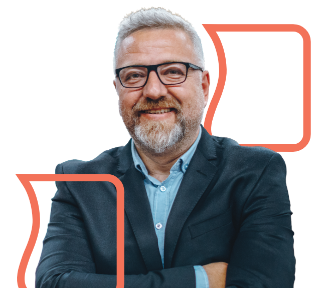 Smiling man with gray hair and beard, wearing glasses and a suit, against a black background with orange Heartland Bank logo outlines.