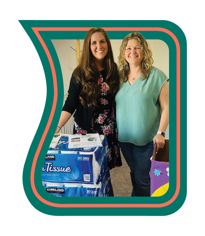 two heartland bank employees standing next to donated goods